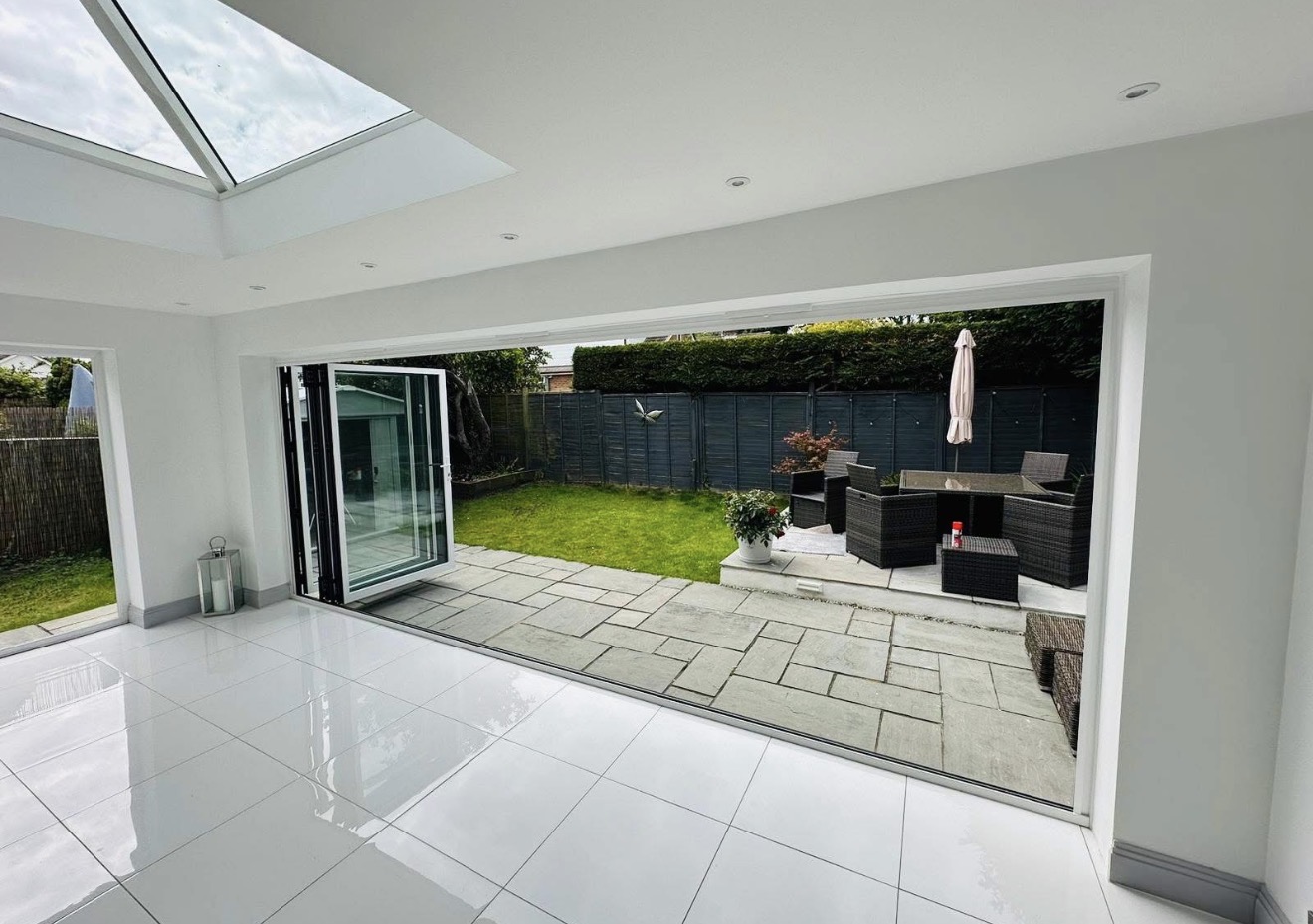 White bi-fold doors open from a bright interior to the garden