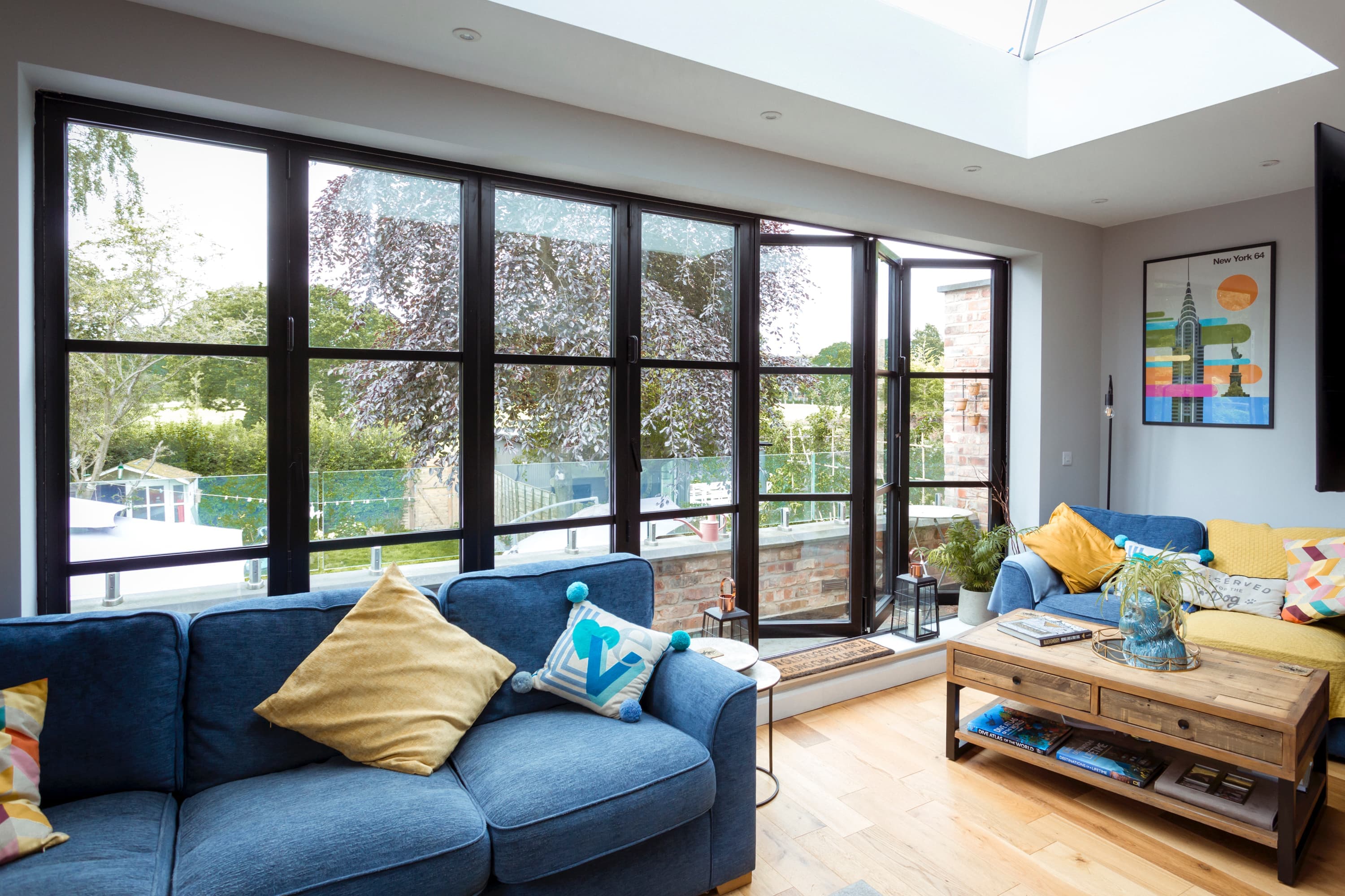 Wide black bi-fold doors open in a bright living room