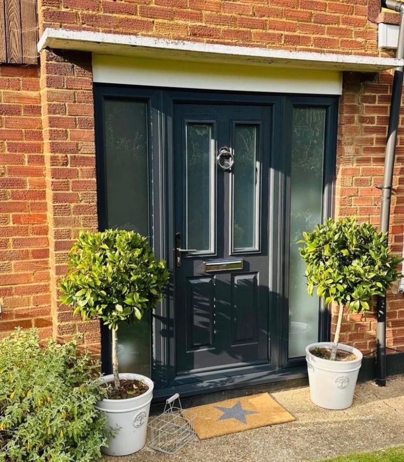 Navy composite front door with sidelights on a brick entrance