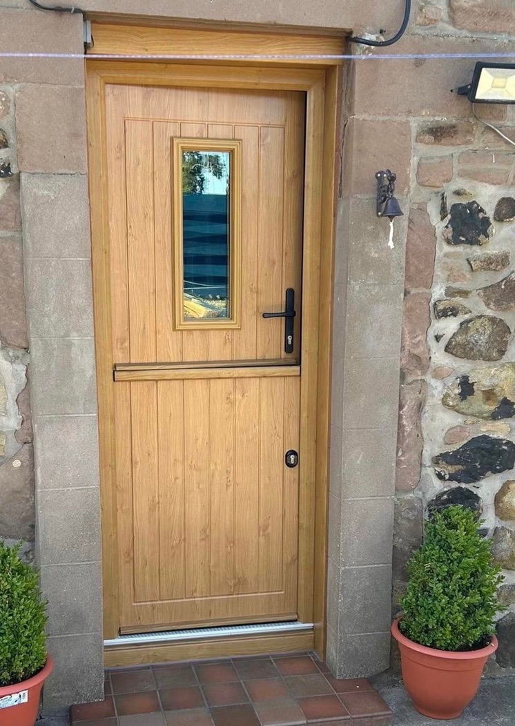 Oak-effect composite stable door installed on a stone cottage