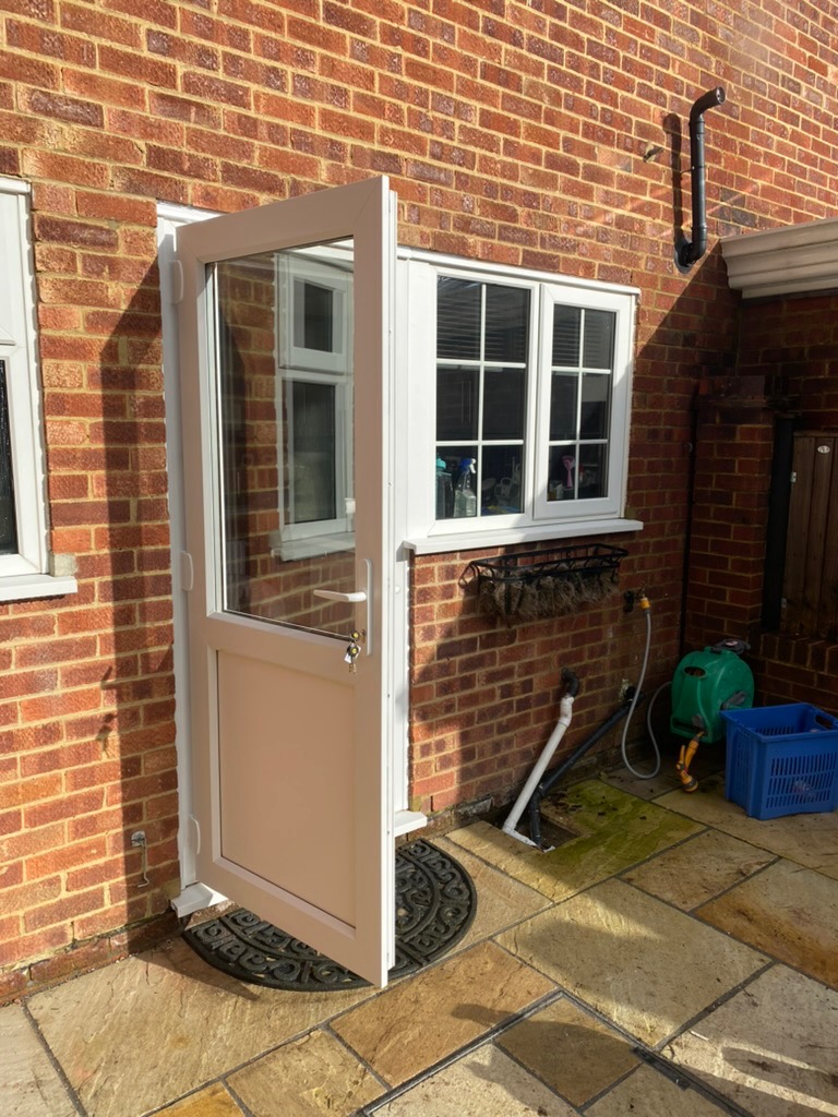 Taupe UPVC back door open on a brick property