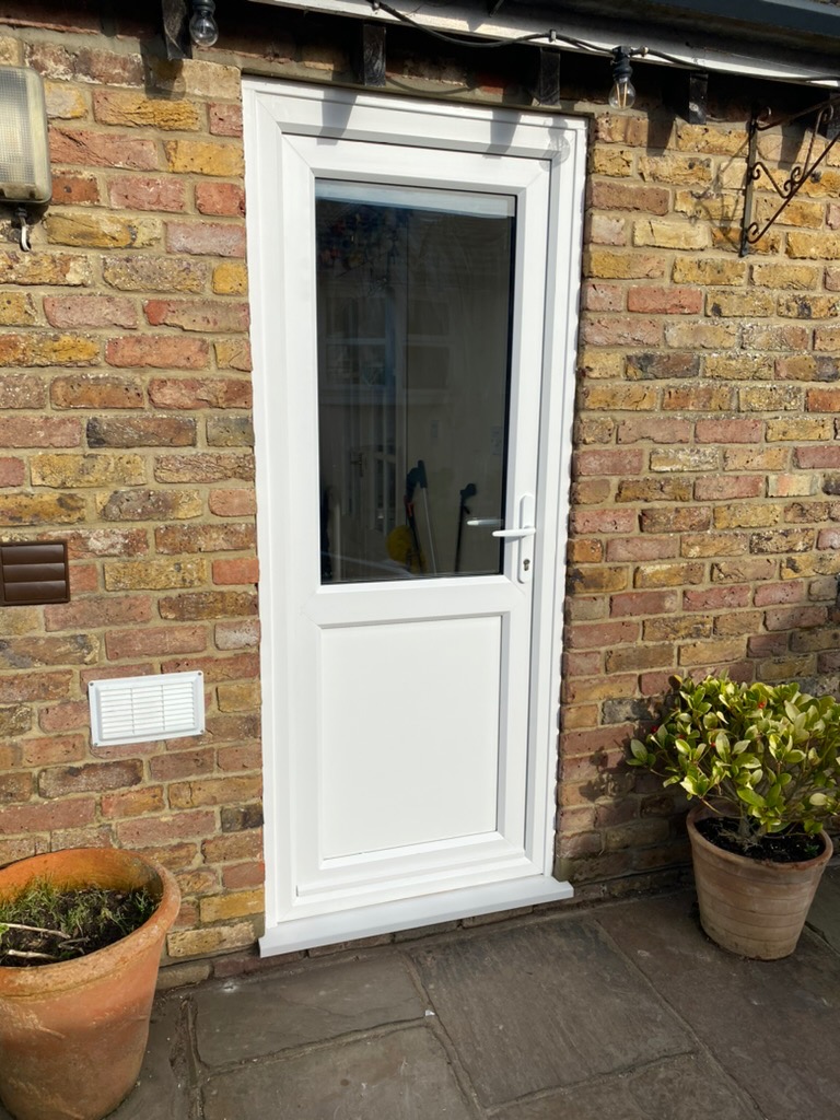 White UPVC back door viewed at an angle on a brick wall
