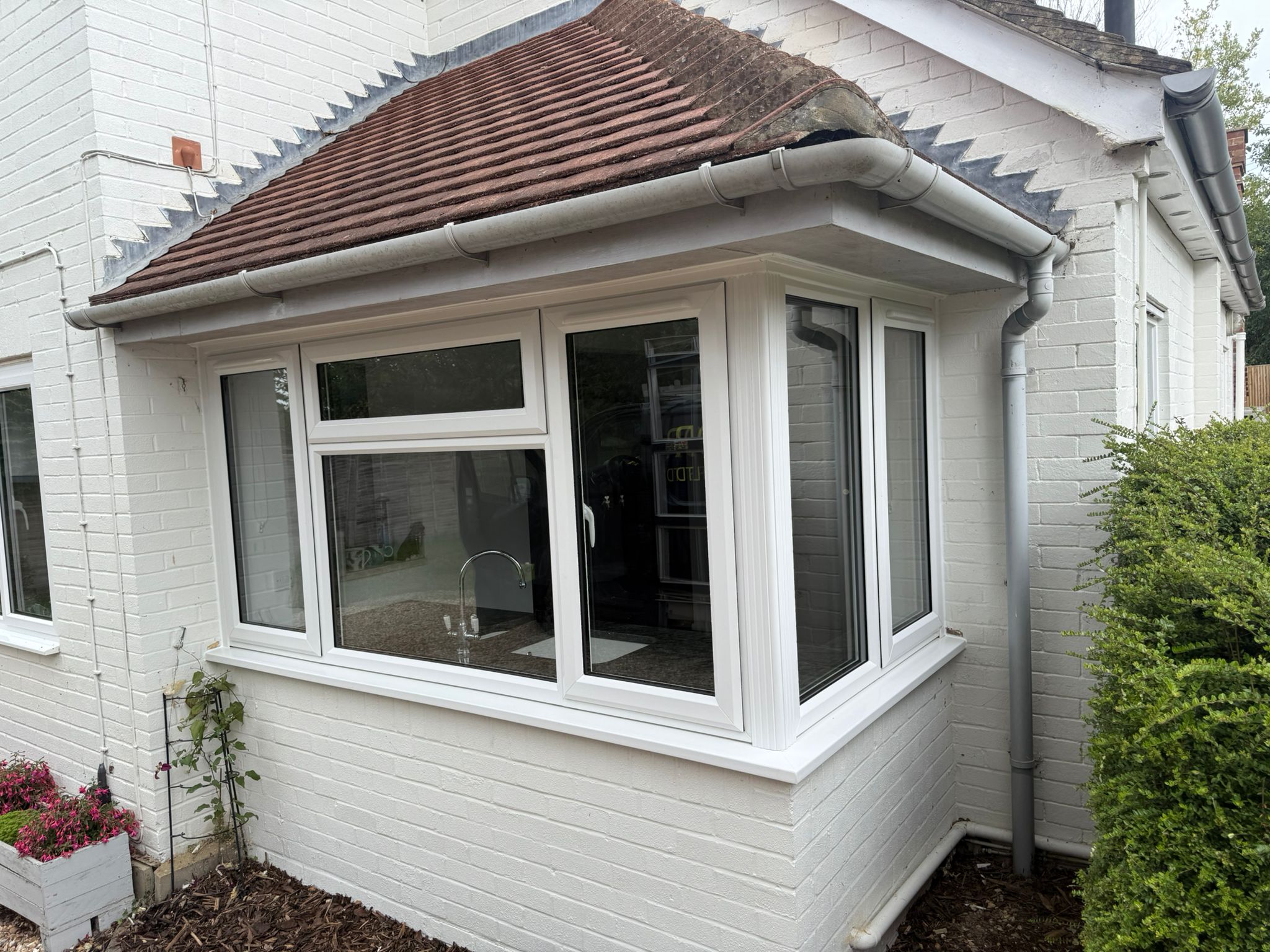 White UPVC casement bay window on a rendered house extension
