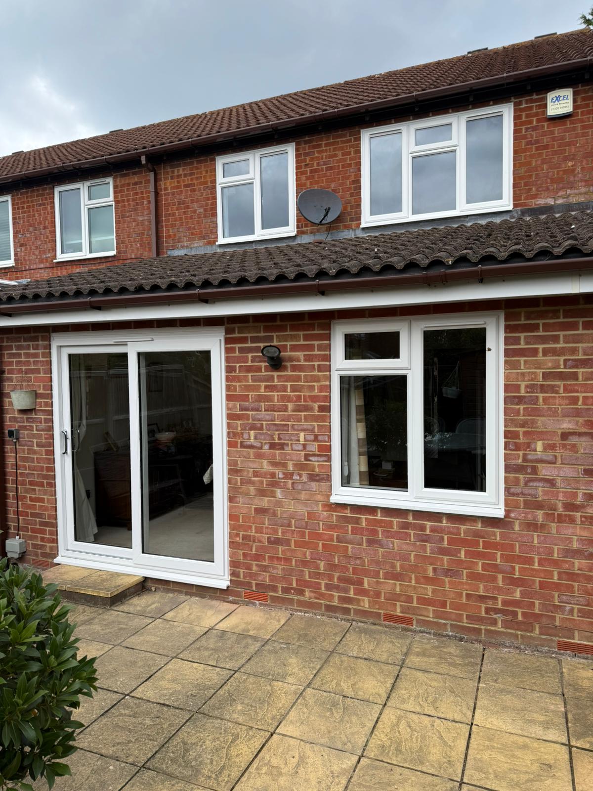 White UPVC casement windows and sliding patio door on a brick terrace