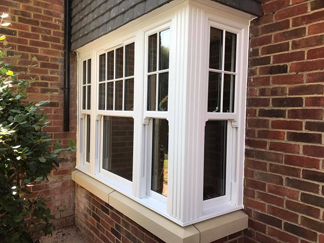 White UPVC sash bay window on a brick house