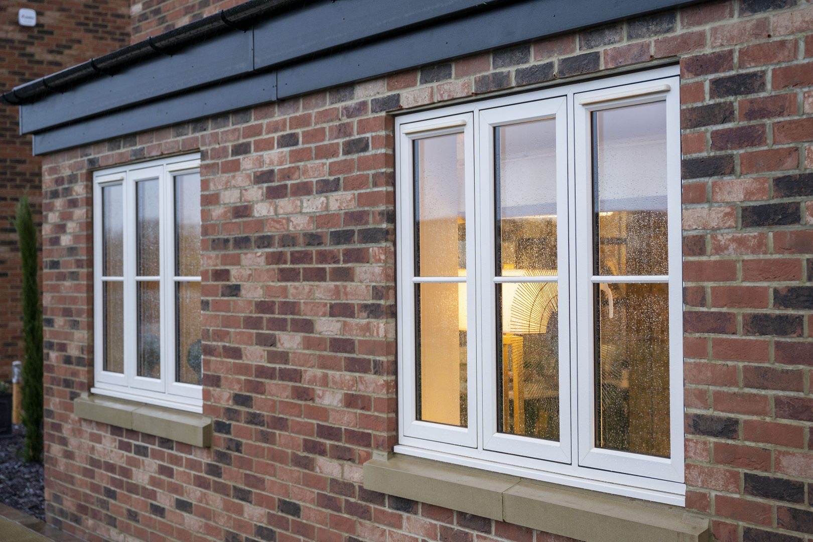 White flush casement windows on a red brick house